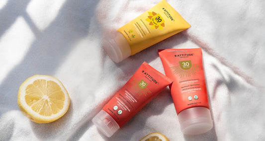Crème solaire minérale ATTITUDE sur une serviette blanche avec des citrons