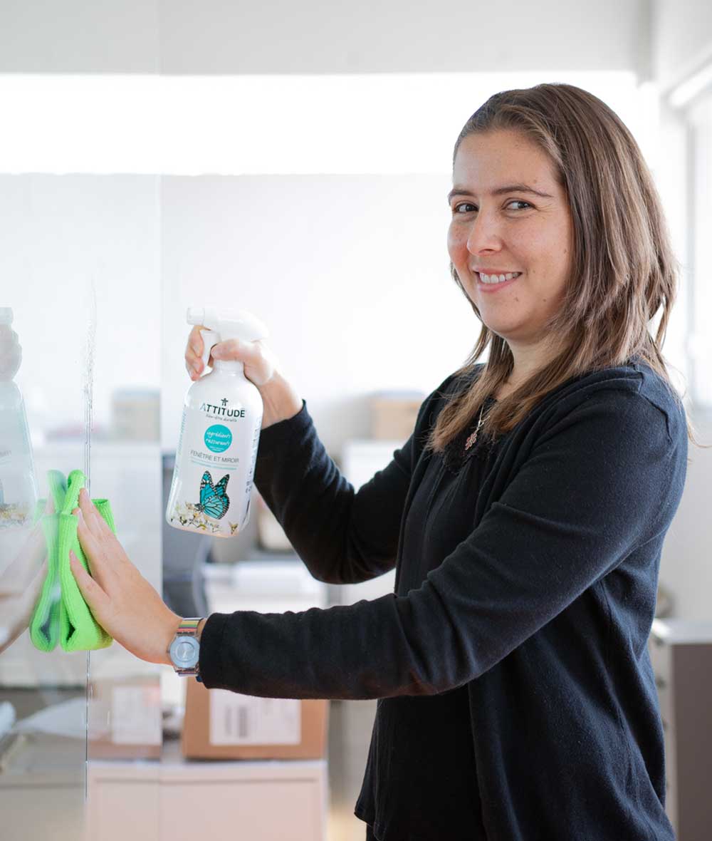 Femme qui nettoie une porte en vitre utilisant ATTITUDE Nettoyant fenêtre et miroir Zestes d'agrumes 10280_fr?_hover?