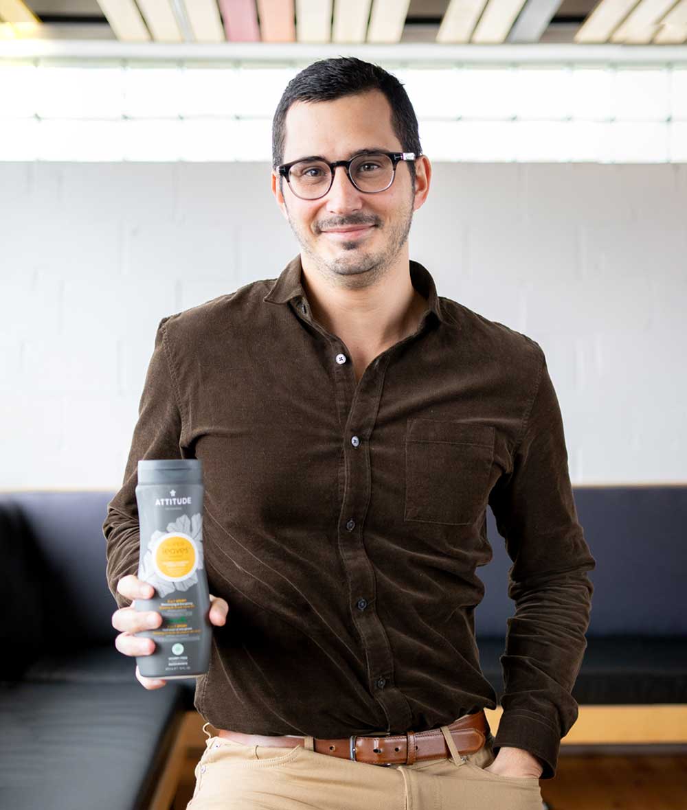 Homme souriant et montrant le Shampooing naturel 2 en 1 homme Hydratant et énergisant ATTITUDE_fr?_team?