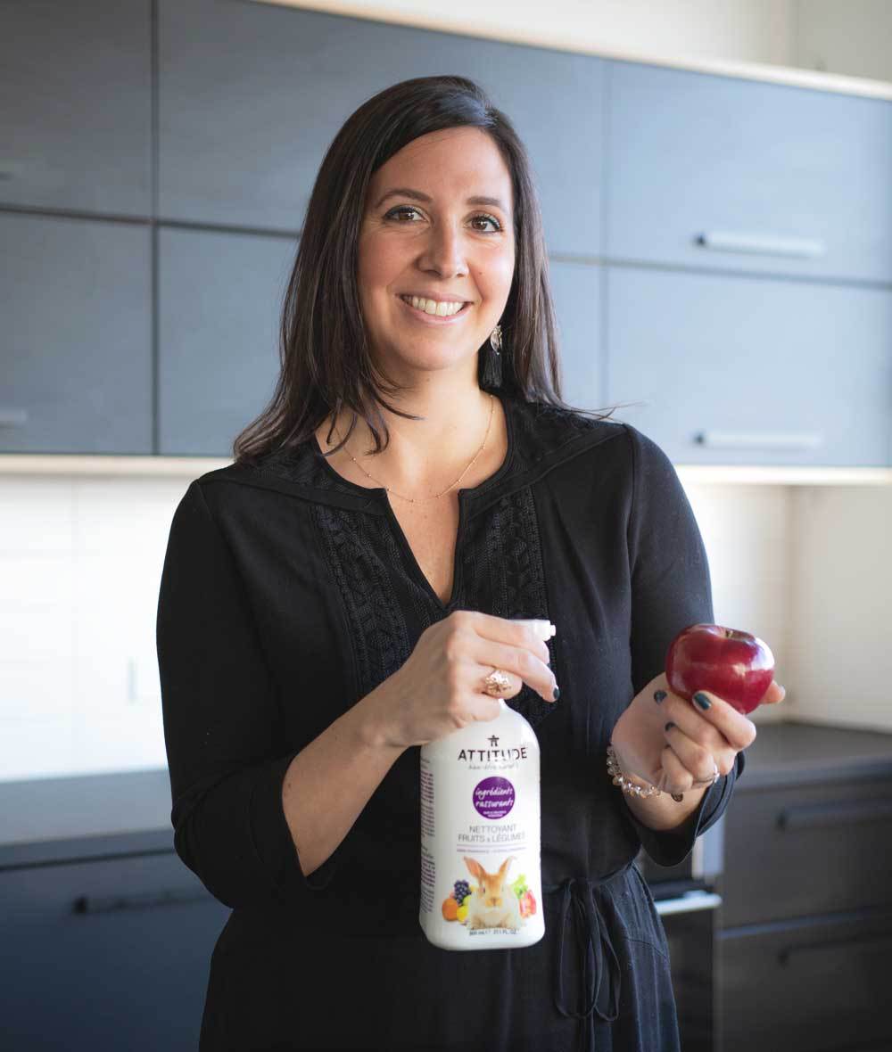 Femme debout qui vaporise sur une pomme le Nettoyant pour fruits et légumes ATTITUDE 10780_fr?_hover? Bouteille 800 mL 